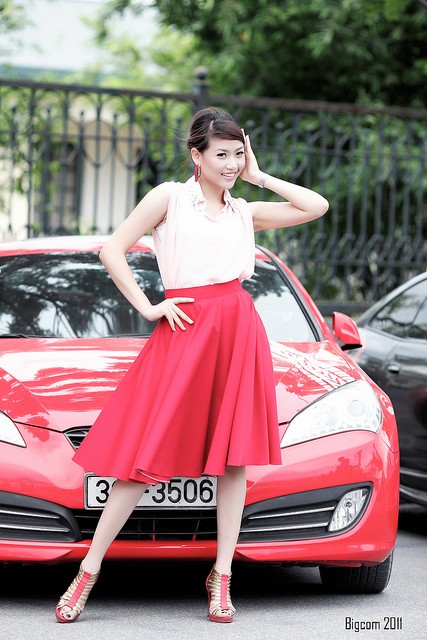 Lấy bối cảnh màu chủ đạo là màu đỏ, người đẹp diện váy đỏ nữ tính và sang trọng sánh vai cùng chiếc xe đắt giá hợp tông màu.